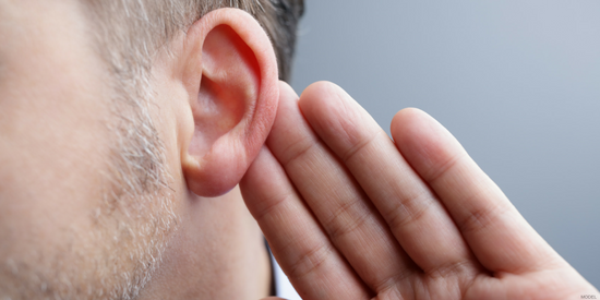Close up of man cupping his ear with a hand